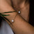Bracelet doré au poignet avec pendentif rond en nacre