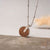 Collier avec pendentif rond en bois et œillet sur cordon argenté