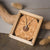 Collier avec pendentif rond en bois dans un plateau rectangulaire en bois