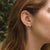 Boucles d'oreilles rondes en bois avec monture argentée et disque en bois, sur le côté de l'oreille