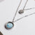 Collier en argent avec pendentif rond en nacre et breloque à motif