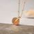 Collier avec chaîne dorée et pendentif rond en bois, avec une petite découpe