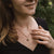 Collier sur le décolleté : chaîne dorée avec pendentif rond en bois