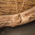 Collier avec pendentif rond en bois et chaîne dorée sur un morceau de bois