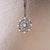 Pendentif flocon de neige argenté avec pierre bleue sur chaîne