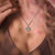 Collier flocon de neige avec pendentif bleu, porté sur le décolleté
