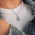 Collier avec chaîne fine et pendentif carré orné d'une pierre claire