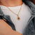 Collier doré avec petit pendentif goutte et pierre rouge
