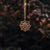 Pendentif de collier doré avec pierre violette en motif floral filigrané