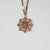 Collier doré avec pendentif rond et pierre violette dans une bordure ornementale