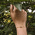 Bracelet au poignet avec chaîne dorée et rondelle en bois