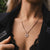 Collier sur le décolleté avec pendentif rond et motif rayonnant aspect métal.