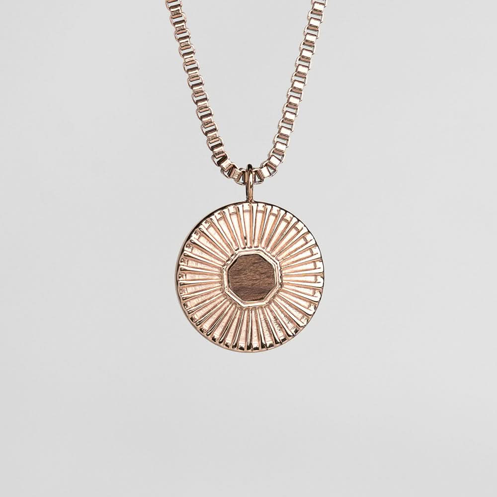 Collier argenté avec pendentif rond et fin relief d'éclats.