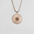 Collier argenté avec pendentif rond et fin relief d'éclats.