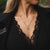 Collier avec pendentif rond et pierre verte, porté sur le décolleté