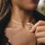 Collier en or avec pendentif rond et pierre verte, près du fermoir