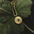 Collier en or avec pendentif rond et pierre verte, vue de face