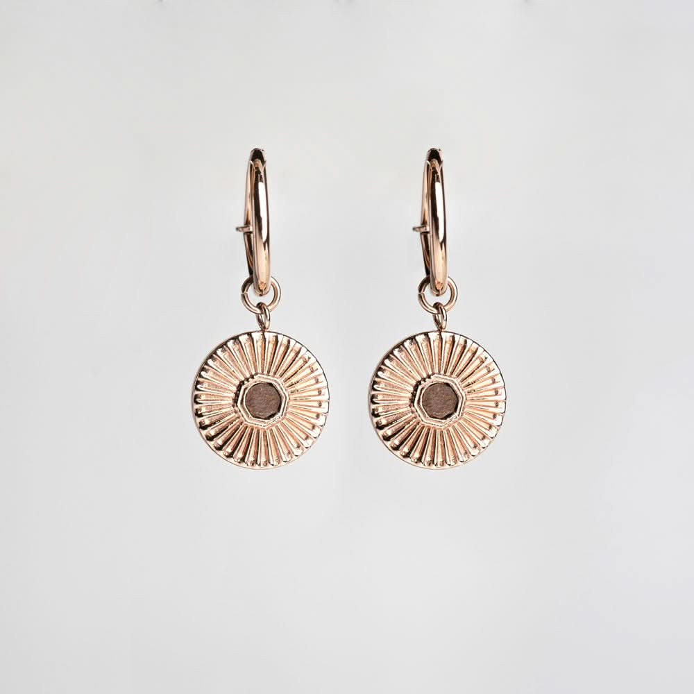 Paire de boucles d'oreilles avec pendentif rond à motif rayonnant et petite bague au centre