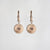 Paire de boucles d'oreilles avec pendentif rond à motif rayonnant et petite bague au centre