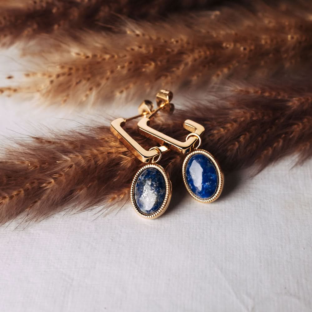 Puces d'oreilles dorées avec pierres ovales bleues et pendentifs carrés