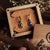 Boucles d'oreilles ovales en pierre bleue avec monture dorée, dans une boîte en bois
