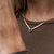 Collier doré avec pendentif carré et pierre turquoise sur le décolleté