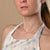 Collier de perles avec de petites perles blanches et une chaîne dorée autour du cou