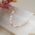 Collier doré avec perles blanches et chaîne à maillons fins