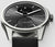 Façade de montre connectée avec cadran gris, boîtier argenté, bracelet noir et affichage de la température