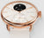 Montre connectée pour femme avec boîtier couleur or rose, bracelet beige et affichage de la température sur cadran noir.