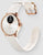 Montre connectée avec lunette or rose, bracelet beige et dessous de bracelet visible avec marquages.