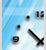 Wanduhr im Detail: schwarze Zeiger, Ziffern 9 und 12, Punkte auf hellem Blau