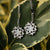 Boucles d'oreilles goutte argentées avec lune ronde en pierre de lune sur des feuilles tachetées