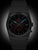 Bracelet de montre pour homme en métal sombre, cadran sombre avec index bleus, date 25