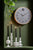 Horloge murale avec cadran gris et cadre en bois clair sur le mur