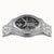 Herrenarmbanduhr von schräg vorn mit sichtbaren Mechanikdetails im Glas und silberfarbenem Band