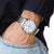 Chronographe pour homme au poignet avec bracelet en acier inoxydable argenté et cadran rond bleu