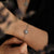 Bracelet en argent avec pierre grise ronde dans un ornement floral au poignet.