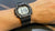 Montre numérique pour homme au poignet avec bracelet noir et écran numérique rétroéclairé