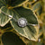 Bracelet en argent avec cabochon rond gris dans un ornement floral sur une chaîne.