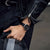 Montre pour homme au poignet : bracelet en cuir noir et boîtier argenté avec cadran sombre