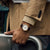 Automatik-Herrenuhr am Handgelenk mit braunem Lederband und weißem Zifferblatt