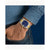 Armbanduhr am Handgelenk mit blauem Zifferblatt und gold-silbernem Edelstahlarmband