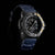 Montre bracelet pour homme, vue de trois quarts, avec boîtier noir, bracelet bleu foncé et index luminescents.