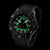 Montre homme noire avec cadran vert lumineux, lunette ronde et bracelet textile noir