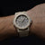 Montre homme au poignet avec bracelet en caoutchouc beige et cadran noir