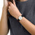 Mondaine-Armbanduhr am Handgelenk mit schwarzem Lederband und rundem weißem Zifferblatt