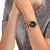 Herrenuhr am Handgelenk mit schwarzem Zifferblatt und roségoldfarbenem Armband