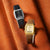 Armbanduhr mit braunem Echtlederband und goldfarbenem Gehäuse auf Stoff