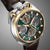 Herrenarmbanduhr mit grünem Zifferblatt, braunem Lederarmband und goldfarbenen Akzenten